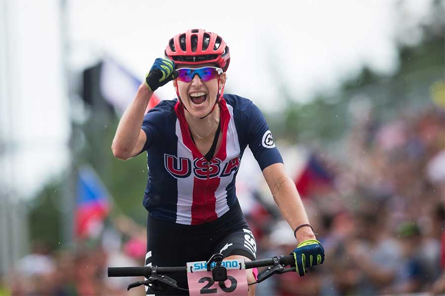 woman on mountain bike with fist raised in triumph